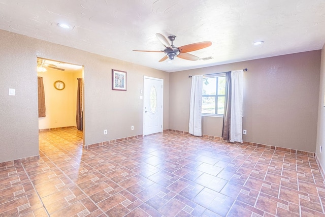 empty room featuring ceiling fan and tile patterned flooring