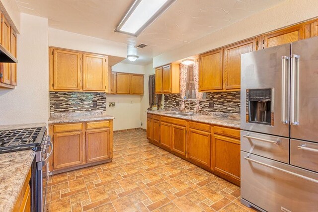 kitchen featuring sink, stainless steel appliances, light tile patterned flooring, and tasteful backsplash