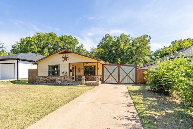 view of front of property featuring a garage, an outbuilding, a porch, and a front yard