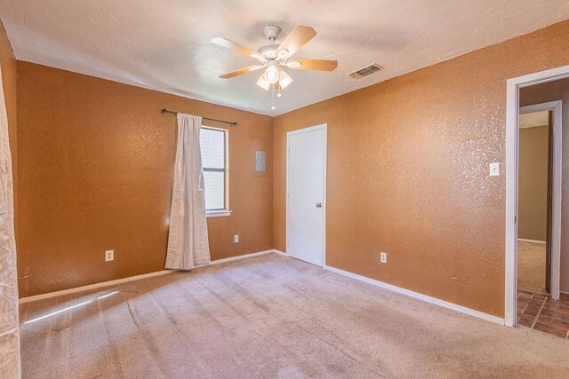 tiled spare room with ceiling fan