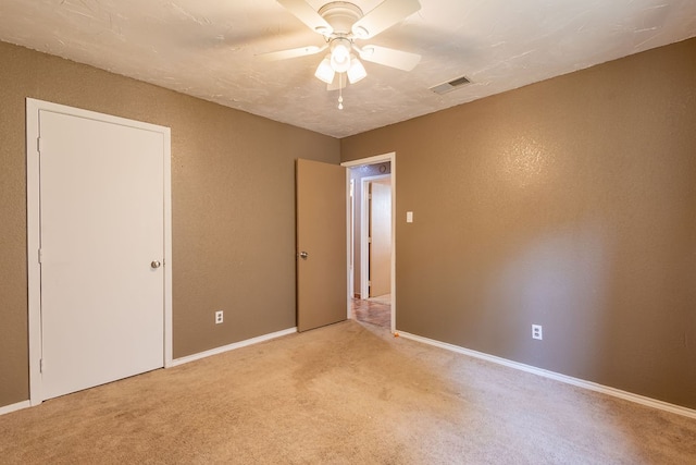 unfurnished room with ceiling fan and light carpet