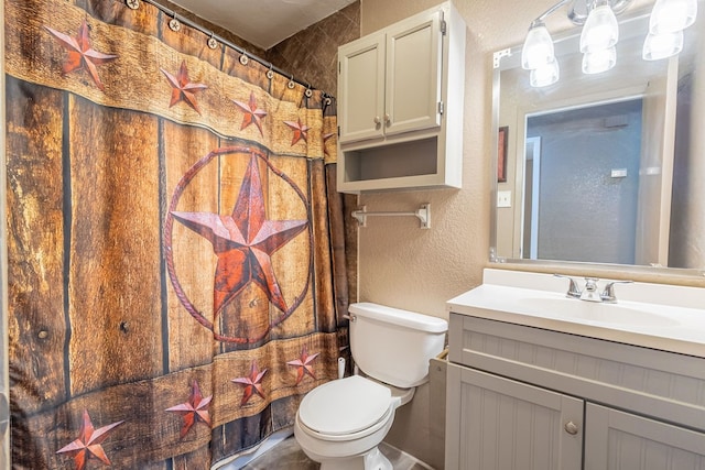 bathroom featuring toilet, vanity, and a shower with curtain