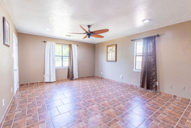 unfurnished room with ceiling fan and tile patterned flooring