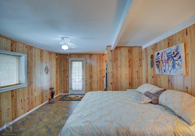 bedroom featuring wood walls and baseboards