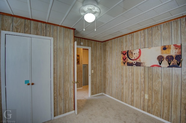 carpeted spare room with wooden walls