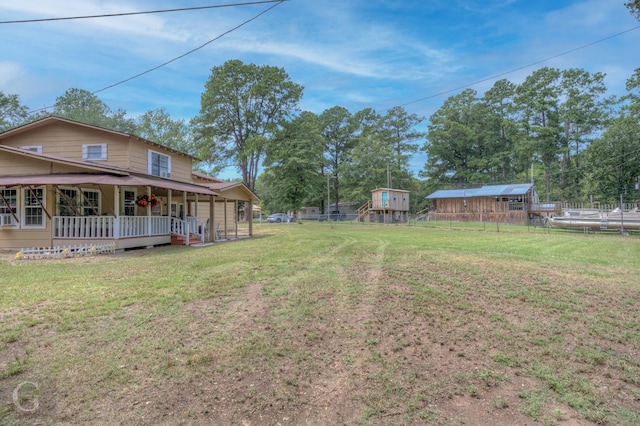 view of yard with covered porch and fence