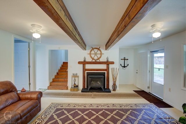 living area featuring beam ceiling and stairs