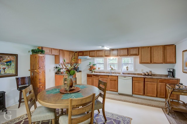 kitchen featuring under cabinet range hood, light countertops, brown cabinets, dishwasher, and a wood stove