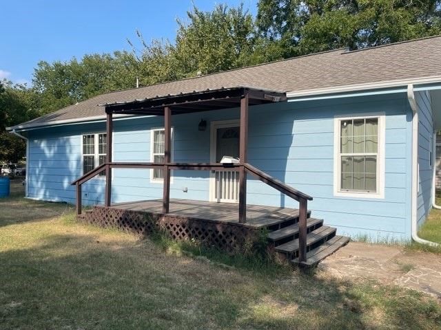 back of house with a deck and a yard