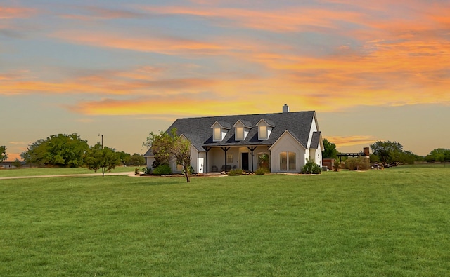 new england style home featuring a yard