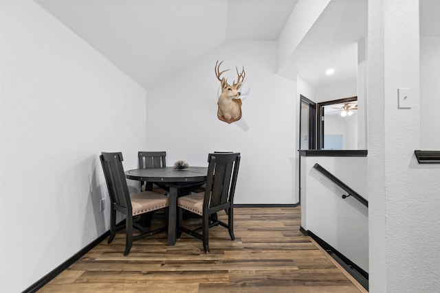 dining space with dark hardwood / wood-style flooring, ceiling fan, and lofted ceiling