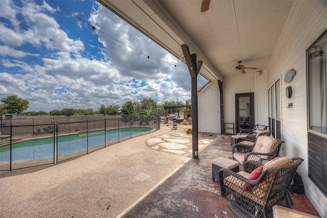 view of patio featuring a fenced in pool and ceiling fan