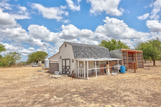 back of house featuring an outdoor structure