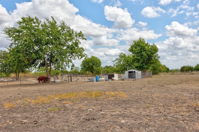 view of yard with a rural view and an outdoor structure