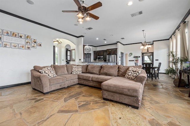 tiled living room featuring ornamental molding, ceiling fan with notable chandelier, and plenty of natural light