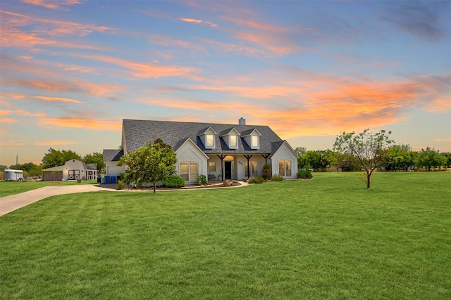 cape cod house with a lawn