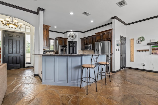 kitchen featuring dark stone countertops, tile patterned flooring, dark brown cabinets, a chandelier, and appliances with stainless steel finishes