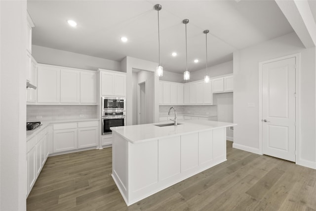 kitchen with a center island with sink, white cabinetry, and stainless steel appliances