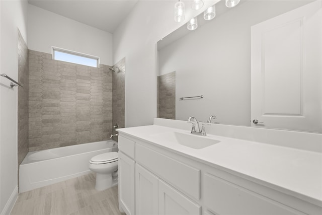 full bathroom with vanity, tiled shower / bath combo, and toilet