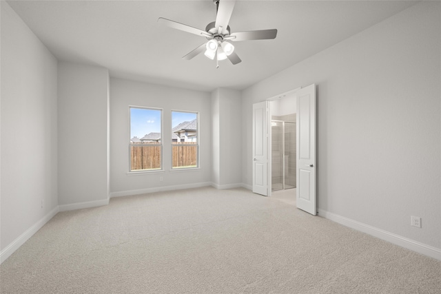 carpeted spare room featuring ceiling fan