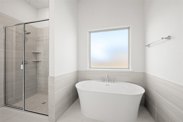 bathroom with tile patterned floors, independent shower and bath, and tile walls