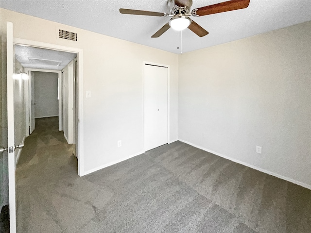 unfurnished bedroom with a textured ceiling, carpet floors, ceiling fan, and a closet