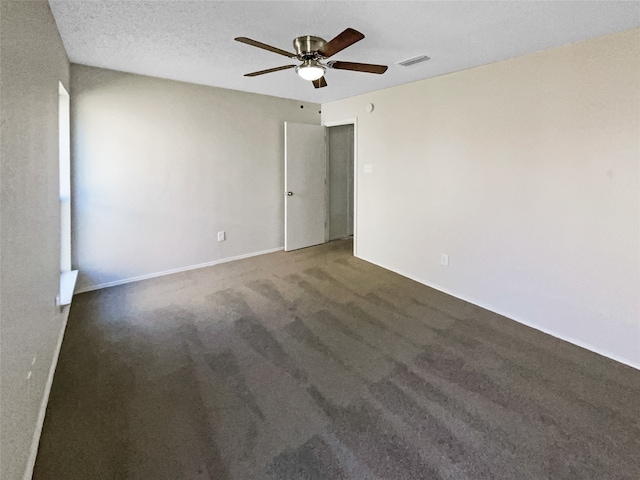 carpeted empty room featuring ceiling fan and a textured ceiling