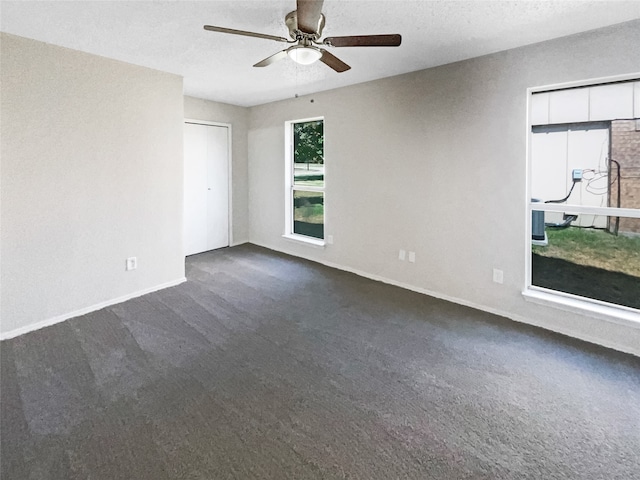 carpeted empty room with ceiling fan and a textured ceiling