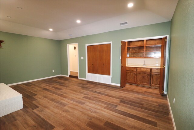 unfurnished bedroom with bar and dark hardwood / wood-style flooring