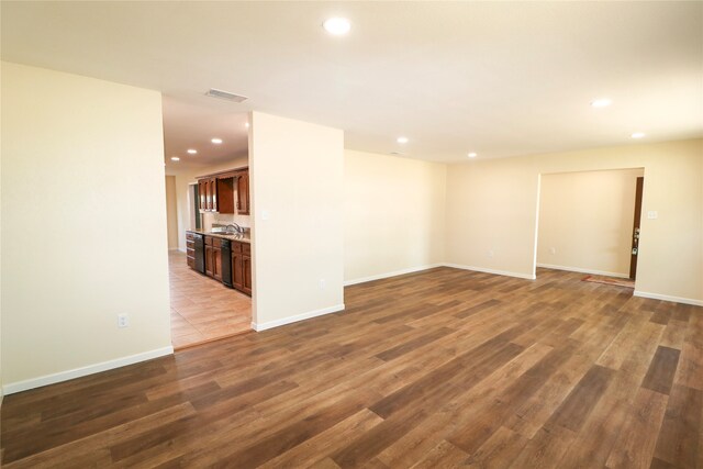 spare room featuring wood finished floors, a sink, visible vents, and recessed lighting