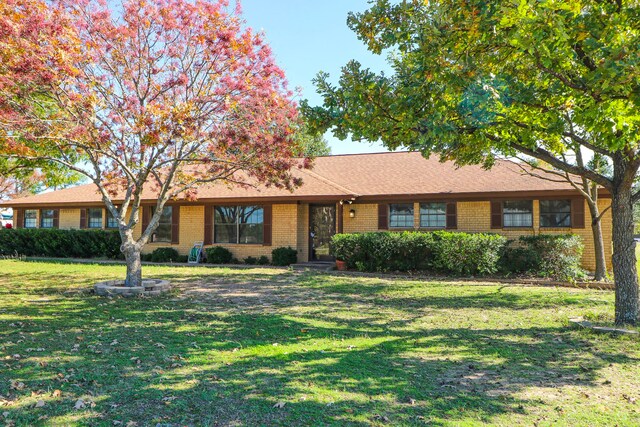 ranch-style home featuring a front lawn and brick siding