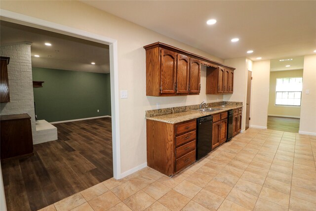 kitchen with black dishwasher, baseboards, light stone counters, a fireplace, and recessed lighting