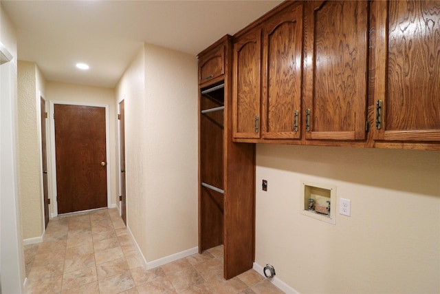 clothes washing area featuring cabinet space, hookup for a washing machine, electric dryer hookup, and baseboards