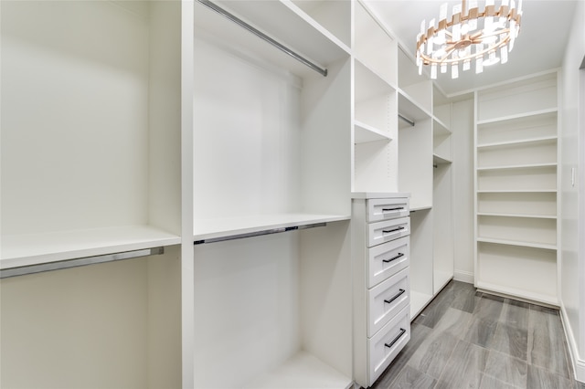 walk in closet featuring an inviting chandelier and wood-type flooring