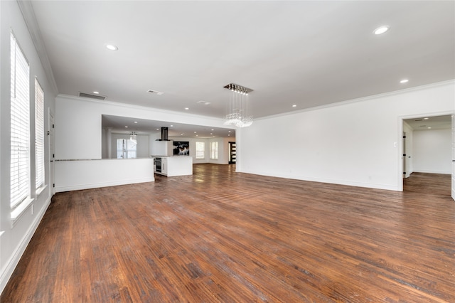 unfurnished living room featuring hardwood / wood-style floors and crown molding