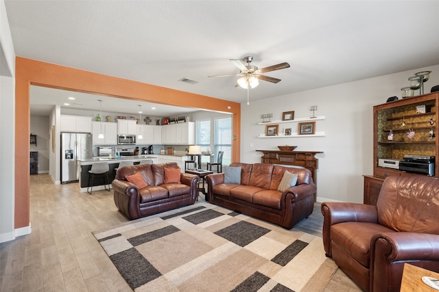 living room with light hardwood / wood-style floors and ceiling fan