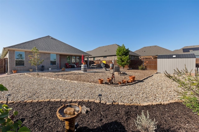 back of property with a storage shed and a patio area