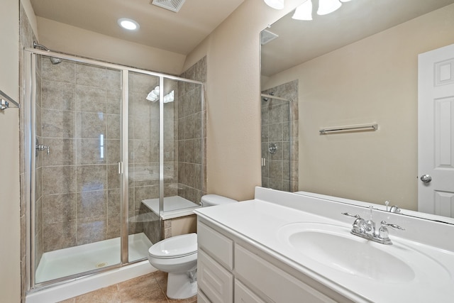 bathroom featuring tile patterned flooring, a shower with shower door, vanity, and toilet