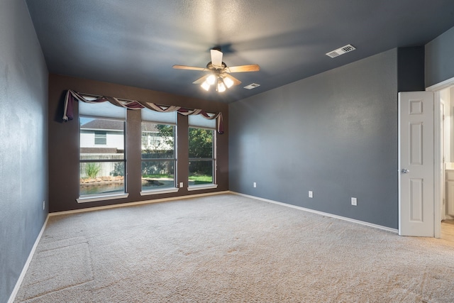 empty room featuring ceiling fan and carpet