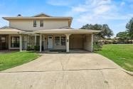 farmhouse inspired home featuring a front lawn and a carport