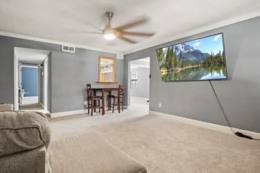 dining area featuring ceiling fan, ornamental molding, and carpet flooring