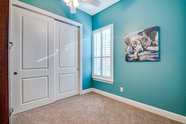 unfurnished bedroom featuring ceiling fan, a closet, and carpet