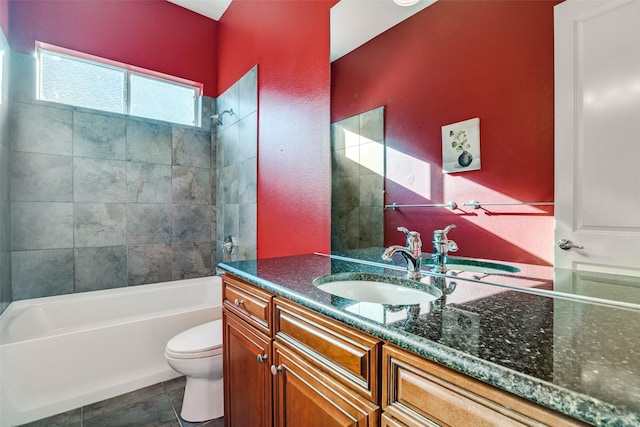 full bathroom featuring tiled shower / bath, tile patterned flooring, vanity, and toilet