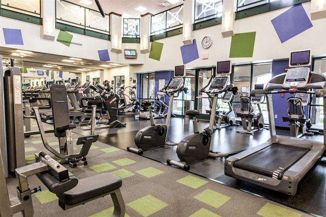 gym with a paneled ceiling and a high ceiling