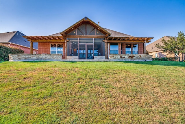 back of property with a lawn and a sunroom