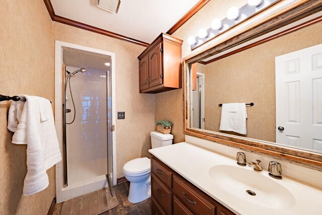 bathroom with ornamental molding, vanity, tile patterned floors, tiled shower, and toilet