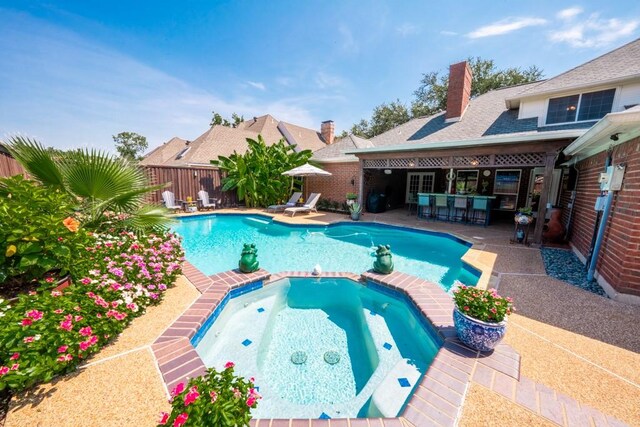 view of swimming pool with a patio area and an in ground hot tub