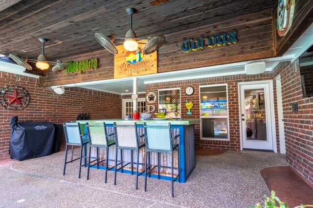 bar with carpet floors, wooden ceiling, pendant lighting, and brick wall