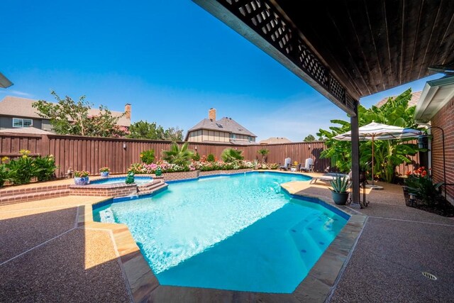 view of pool featuring a patio area and an in ground hot tub