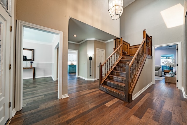 staircase featuring a high ceiling and hardwood / wood-style floors